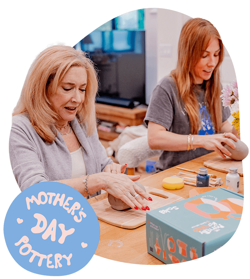 A mother and daughter share a joyful moment, hand-crafting clay pieces together in a warm space with the text "Mother’s Day Pottery" overlaid on the image