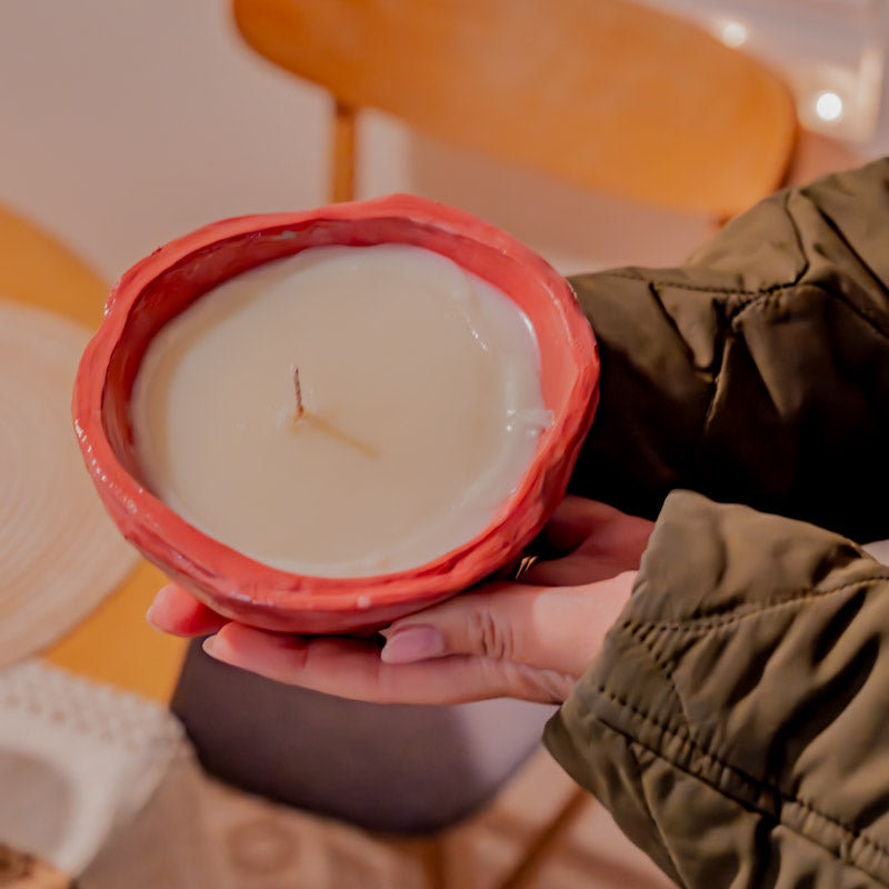 Sculpd Candle Making Kit Pot with drying wax held by hands and a stylized background